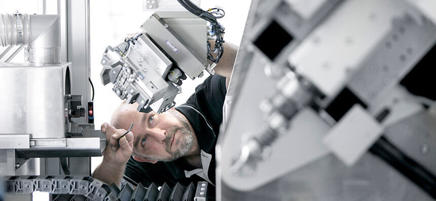 Pracovník sklánějící se nad strojem