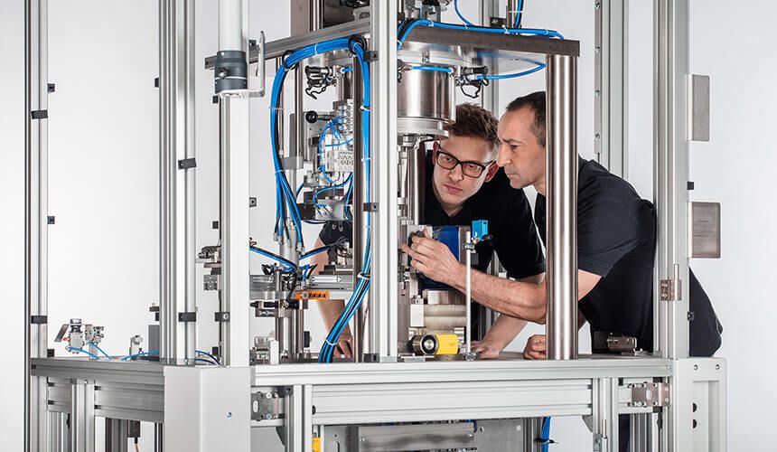 Zwei Mitarbeiter montieren eine Maschine - ZELTWANGER Maschinenbau